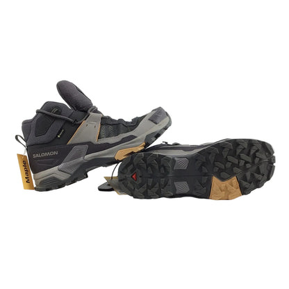 Pair of black hiking boots with orange accents on a white background